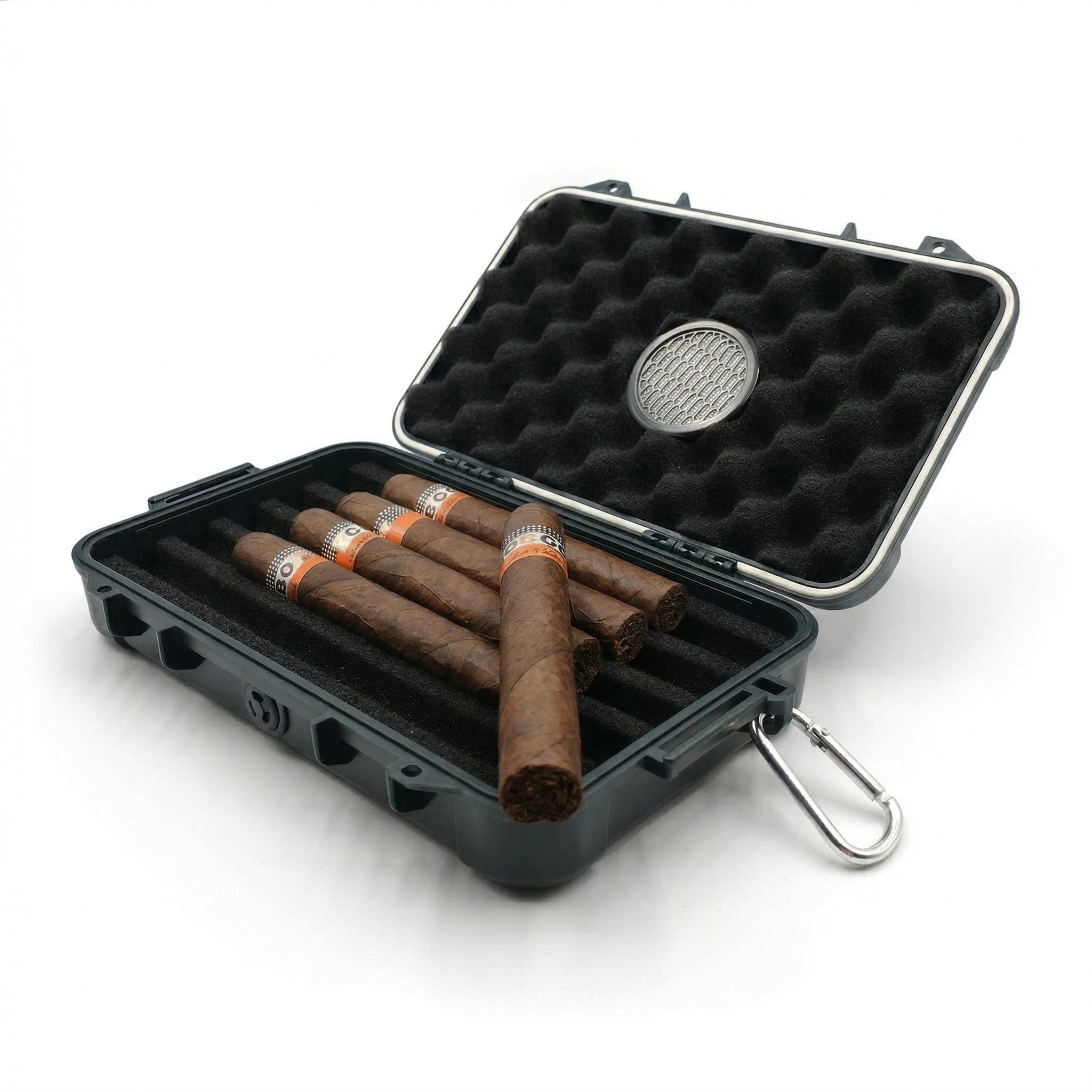 Open matte black hard-shell waterproof travel cigar case with black egg-crate foam interior holding 5 premium cigars and a circular humidifier disc in the lid, silver carabiner attached, white background